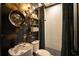 Luxurious bathroom with stylish wallpaper, vessel sink, and shower with curtain at 7705 Weeping Willow Cir, Sarasota, FL 34241