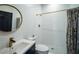 Well-lit bathroom with modern fixtures, decorative mirror, and a shower with white tile at 7705 Weeping Willow Cir, Sarasota, FL 34241