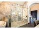 Bright bathroom with elegant marble tile, glass shower, and modern gold fixtures at 7705 Weeping Willow Cir, Sarasota, FL 34241