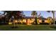 Dusk view of a luxury home with beautiful landscaping, ambient lighting, and manicured lawn at 7705 Weeping Willow Cir, Sarasota, FL 34241