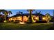 Stunning dusk view of an immaculate home enhanced with elegant landscaping and illuminated accents at 7705 Weeping Willow Cir, Sarasota, FL 34241