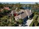 Stunning lakefront home boasts lush landscaping, a circular driveway, and a grand entrance at 7705 Weeping Willow Cir, Sarasota, FL 34241