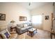 Cozy living room featuring a comfortable sofa, armchair, and ample natural light at 7705 Weeping Willow Cir, Sarasota, FL 34241
