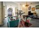 Elegant living room with a fireplace, grand piano, statement lighting, and colorful accents creating a unique and inviting space at 7705 Weeping Willow Cir, Sarasota, FL 34241