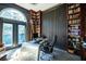 Spacious office space featuring floor to ceiling bookshelves, large windows, and stylish decor at 7705 Weeping Willow Cir, Sarasota, FL 34241