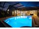 Backyard oasis featuring a sparkling pool, outdoor dining, and hot tub area at 7705 Weeping Willow Cir, Sarasota, FL 34241