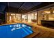 Backyard oasis featuring a sparkling pool, outdoor dining, and hot tub area at 7705 Weeping Willow Cir, Sarasota, FL 34241
