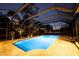 Beautiful in-ground pool surrounded by a screened enclosure and lush landscaping at 7705 Weeping Willow Cir, Sarasota, FL 34241