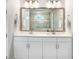 Bright bathroom with a large mirror, double vanity, and bright modern lights at 31534 Westbury Estates Ave, Wesley Chapel, FL 33545