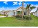 Charming single-story home with fresh green grass, palm trees, and colorful plants at 31534 Westbury Estates Ave, Wesley Chapel, FL 33545