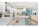 Bright kitchen features white cabinets, quartz counters, stainless appliances and island seating at 31534 Westbury Estates Ave, Wesley Chapel, FL 33545