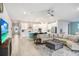 Open-concept living area boasts a large sectional, ceiling fan, dining area and kitchen at 31534 Westbury Estates Ave, Wesley Chapel, FL 33545
