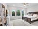 Spacious main bedroom with serene lighting, three windows, and a decorative rug at 31534 Westbury Estates Ave, Wesley Chapel, FL 33545