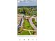Aerial view of a community entrance with landscaped grounds, pool and lush greenery, creating an inviting first impression at 12209 Putter Green Ct, New Port Richey, FL 34654