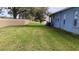 Expansive backyard with lush green lawn, mature trees, and partial view of a neighboring home at 12209 Putter Green Ct, New Port Richey, FL 34654