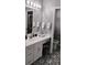 Well-lit bathroom featuring a dual sink vanity, patterned floors, modern fixtures, and a clean, organized space at 12209 Putter Green Ct, New Port Richey, FL 34654