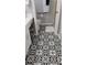 Beautiful bathroom with elegant black and white patterned tile flooring, and a walk-in shower behind a doorway at 12209 Putter Green Ct, New Port Richey, FL 34654