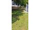 Grassy front yard with scattered leaves and a 'For Sale' sign at 12209 Putter Green Ct, New Port Richey, FL 34654