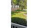 A front yard with freshly cut grass and a tree with a mulch bed at 12209 Putter Green Ct, New Port Richey, FL 34654