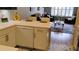 Bright kitchen featuring white cabinets, a modern dishwasher, and an open view into the living room at 12209 Putter Green Ct, New Port Richey, FL 34654