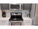 Close up of a well-equipped kitchen featuring stainless steel appliances and white countertops at 12209 Putter Green Ct, New Port Richey, FL 34654