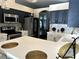 Modern kitchen features stainless steel appliances, gray cabinets and white countertops at 12209 Putter Green Ct, New Port Richey, FL 34654