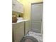 This laundry room is equipped with full-size washer and dryer units, accompanied by modern gray accent walls and marble floors at 12209 Putter Green Ct, New Port Richey, FL 34654