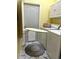 Functional laundry room with washer, dryer, storage cabinets, ironing board, and stylish marble tile flooring at 12209 Putter Green Ct, New Port Richey, FL 34654