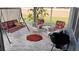Screened-in patio features tile floors, swing, grill, and chairs with floral cushions perfect for outdoor relaxation at 12209 Putter Green Ct, New Port Richey, FL 34654