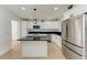 Modern kitchen featuring white cabinets, stainless steel appliances, and black countertops at 1766 12Th N Ave, St Petersburg, FL 33713