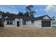 New construction displays a charming one-story home with modern windows, black trim, and a two-car garage at 2607 Seagull Ln, North Port, FL 34286