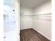 Bright walk-in closet featuring shelving and laminate floors, plus a bathroom nearby at 2607 Seagull Ln, North Port, FL 34286