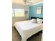 Bedroom with a queen-size bed, white linens, a side table, and a window with white shutters at 19417 Gulf Blvd # B209, Indian Rocks Beach, FL 33785