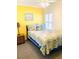 Bedroom featuring a bed with tropical bedding, a side table, and a window with white shutters at 19417 Gulf Blvd # B209, Indian Rocks Beach, FL 33785
