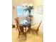 Dining area featuring a glass table, bamboo chairs, and natural light from a window at 19417 Gulf Blvd # B209, Indian Rocks Beach, FL 33785