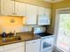 Kitchen featuring white cabinets, granite countertops, and stainless steel appliances, near a window at 19417 Gulf Blvd # B209, Indian Rocks Beach, FL 33785