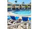 Community pool with blue lounge chairs and nearby condominium buildings on a bright, sunny day at 19417 Gulf Blvd # B209, Indian Rocks Beach, FL 33785