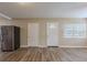 Open living space with wood floors, two entry doors, and a view of the refrigerator at 3408 Phillips St, Tampa, FL 33619