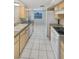 Functional kitchen featuring ample cabinetry, white appliances, and tile flooring at 5321 Baroque Dr, Holiday, FL 34690