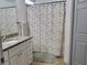 Bathroom with a granite countertop, vanity, towel rack, and shower with patterned curtain at 22621 Saint Thomas Cir, Lutz, FL 33549