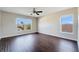 Large bedroom with a ceiling fan, dark floors, and two windows for natural light at 15107 Searobbin Dr, Lakewood Ranch, FL 34202