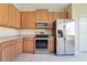 Bright kitchen featuring stainless steel appliances, wooden cabinets, and tile flooring at 15107 Searobbin Dr, Lakewood Ranch, FL 34202