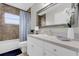 Elegant bathroom with white cabinetry, decorative mirror, and garden tub at 2727 Brookville Dr, Valrico, FL 33596