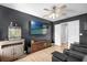 Modern bedroom with dark walls, wood floors, a ceiling fan, and entertainment setup at 2727 Brookville Dr, Valrico, FL 33596