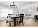 Bright dining room with a wooden table, modern chandelier, and large windows for natural light at 2727 Brookville Dr, Valrico, FL 33596