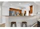 A breakfast bar with stools overlooks the kitchen with stainless appliances and wooden cabinets at 2727 Brookville Dr, Valrico, FL 33596