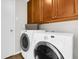 A laundry room featuring a washer and dryer along with upper wooden cabinets at 2727 Brookville Dr, Valrico, FL 33596