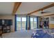 Bedroom featuring natural beams, a ceiling fan, and sliding glass doors to the balcony at 373 Hile Ln, Punta Gorda, FL 33982