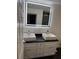 Stylish bathroom featuring double sinks with white cabinets and a large mirror at 501 Knights Run Ave # 2106, Tampa, FL 33602