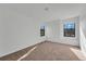 Bright bedroom featuring neutral carpet and dual sunlit windows at 7108 Harvest Glen Ln, Riverview, FL 33578